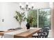 Elegant dining room with a chandelier, large window, and a rustic wooden table at 8164 S York Ct, Centennial, CO 80122