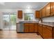 Bright kitchen with wood cabinets and a large window and sliding glass doors to deck at 8164 S York Ct, Centennial, CO 80122