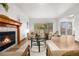 Bright living room with a fireplace, neutral decor, wood floors, large windows, and an outdoor patio view at 8164 S York Ct, Centennial, CO 80122