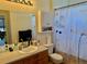 Full bathroom features a wooden vanity with a large mirror and decorative shower curtain at 14353 E 1St Dr # 302, Aurora, CO 80011