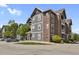Attractive building with red brick and grey siding, manicured lawn and parking area visible at 14353 E 1St Dr # 302, Aurora, CO 80011
