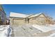 Two-story house with stone accents and a three-car garage, snow on the ground at 22586 E Union Cir, Aurora, CO 80015