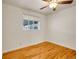 Bedroom showcasing hardwood floors, white walls, ceiling fan, and a window at 7881 Kenwood St, Commerce City, CO 80022