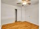 Bedroom featuring hardwood floors, white walls, ceiling fan, closet, and a white door at 7881 Kenwood St, Commerce City, CO 80022