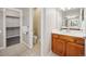 Bathroom with wood vanity, white countertop, walk-in closet, and separate toilet area at 9777 W Stanford Ave, Denver, CO 80123