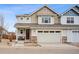 Charming two-story home features a two-car garage, stone accents, and a welcoming front porch at 9777 W Stanford Ave, Denver, CO 80123