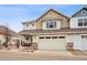 Inviting two-story home with a two-car garage, stone accents, and a cozy front porch with seating at 9777 W Stanford Ave, Denver, CO 80123