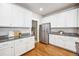 Bright kitchen featuring white cabinets, stainless steel refrigerator, and granite countertops at 9777 W Stanford Ave, Denver, CO 80123