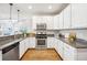 Well-lit kitchen boasts granite countertops, stainless steel appliances, and white cabinetry at 9777 W Stanford Ave, Denver, CO 80123