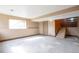 Unfinished basement features stairs, a window for natural light, and neutral-toned walls, offering customization potential at 18950 E Kent Cir, Aurora, CO 80013
