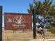 Entrance to Spring Valley Golf Club with a rustic sign amid the lush, green landscape at 42968 Colonial Trl, Elizabeth, CO 80107