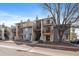 Exterior view of condos with balconies and staircases, showing the building's facade and nearby street under a blue sky at 6011 Yarrow St # C, Arvada, CO 80004