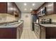 Modern kitchen with granite countertops, stainless steel appliances, and dark wood cabinetry at 6011 Yarrow St # C, Arvada, CO 80004