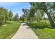 A beautiful park with paved walkways, and mature trees on a sunny day at 6011 Yarrow St # C, Arvada, CO 80004