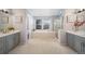 Bright primary bathroom with dual vanities, soaking tub, walk-in shower, and neutral colored walls and carpet at 22668 E Lake Pl, Centennial, CO 80015