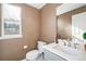 Powder room features a toilet, vanity with grey cabinets, and light countertop next to a window at 22668 E Lake Pl, Centennial, CO 80015
