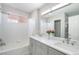 Bright bathroom with a dual sink vanity, tub, and shower combination showcasing modern fixtures at 22668 E Lake Pl, Centennial, CO 80015