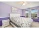 This bedroom features a bed with floral bedding, purple walls, a white nightstand, and a ceiling fan at 22668 E Lake Pl, Centennial, CO 80015