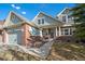Charming two-story home with a brick facade, well-manicured lawn, and inviting front porch at 22668 E Lake Pl, Centennial, CO 80015