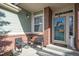 Inviting front porch with seating, brick accents, and a charming front door with a floral wreath at 22668 E Lake Pl, Centennial, CO 80015