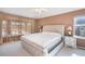 The main bedroom offers a plush bed, neutral walls, a large window with curtains, and a white nightstand at 22668 E Lake Pl, Centennial, CO 80015
