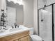Modern bathroom with walk-in shower, white marble-look tile, and a wood vanity with a large mirror at 6880 S Yantley Ct, Aurora, CO 80016