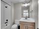 Well-lit bathroom featuring a tub and shower combo, neutral tile, and a vanity with wooden cabinets at 6880 S Yantley Ct, Aurora, CO 80016
