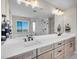 Luxurious bathroom featuring double sinks, quartz countertops, a large mirror, and a glass-enclosed shower at 6880 S Yantley Ct, Aurora, CO 80016