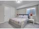 Cozy bedroom with neutral tones, plush carpet, and a comfortable bed with patterned bedding and matching lamps at 6880 S Yantley Ct, Aurora, CO 80016