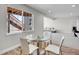Cozy dining area with a glass table and chairs, bright lighting, and a view of the outdoor stairwell at 6880 S Yantley Ct, Aurora, CO 80016
