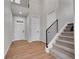 Bright foyer with wood floors, a staircase with iron railing, and a front door with glass panels at 6880 S Yantley Ct, Aurora, CO 80016
