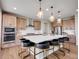 Stylish kitchen island with seating, light wood cabinets, and stainless steel appliances for modern living at 6880 S Yantley Ct, Aurora, CO 80016