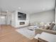 Spacious living room with modern fireplace, recessed lighting, and stylish hardwood flooring at 6880 S Yantley Ct, Aurora, CO 80016