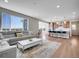 Open-concept living space featuring wood floors, a sectional sofa, and a glimpse of the kitchen at 6880 S Yantley Ct, Aurora, CO 80016