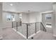 Open loft area with iron railing, neutral carpeting, and abundant natural light from multiple windows at 6880 S Yantley Ct, Aurora, CO 80016