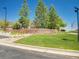 Stone community sign framed by vibrant green landscaping and mature trees at 6880 S Yantley Ct, Aurora, CO 80016