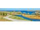 A serene waterfront view showcasing a picturesque lake surrounded by grassy landscapes at 6880 S Yantley Ct, Aurora, CO 80016