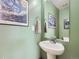 Powder room features a pedestal sink, framed art, and a modern, minimalist design at 17950 E 54Th Ave, Denver, CO 80249