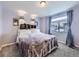 Bedroom with plush carpeting, a decorative headboard, and ample natural light from the window at 17950 E 54Th Ave, Denver, CO 80249