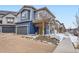 Charming two-story home features blue siding, a covered porch, and an attached garage at 17950 E 54Th Ave, Denver, CO 80249