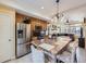 Open concept kitchen with island seating connects seamlessly to living room, featuring stainless appliances at 17950 E 54Th Ave, Denver, CO 80249