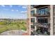 A close up of a multi-story building featuring balconies with outdoor furniture, overlooking a lush park at 2000 Little Raven St # 4A, Denver, CO 80202