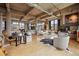 Expansive living area with exposed ceilings, fireplace, dining set, desk, and large windows for natural light at 2000 Little Raven St # 4A, Denver, CO 80202
