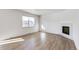 Bright living room featuring hardwood floors and a corner fireplace at 13432 Wabash St, Thornton, CO 80602