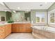 Bright bathroom with dual vanities, corner bathtub, and a large window offering natural light at 30205 Telluride Ln, Evergreen, CO 80439