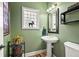 Charming powder room features pedestal sink, toilet and modern fixtures with green walls at 30205 Telluride Ln, Evergreen, CO 80439