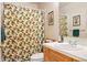 Charming bathroom with patterned shower curtain and a vanity complete with a unique cowboy boot decoration at 30205 Telluride Ln, Evergreen, CO 80439