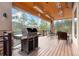 Outdoor deck with a grill, heaters, and beautiful views of the surrounding trees at 30205 Telluride Ln, Evergreen, CO 80439