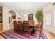 Elegant dining room with a large wooden table, chandelier lighting, and a colorful area rug at 30205 Telluride Ln, Evergreen, CO 80439