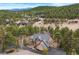 An aerial view of the home showcasing its architectural design and placement among mature pine trees at 30205 Telluride Ln, Evergreen, CO 80439